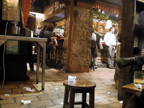 Café met mensen aan de bar en rommel op de grond