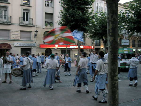 Mensen in klederdracht met trommels en vlaggen