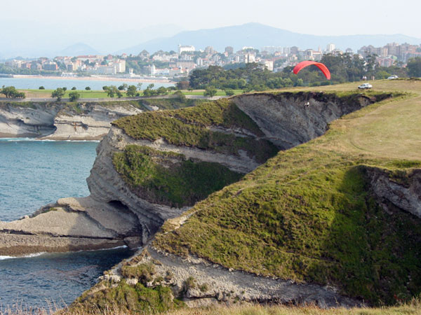 Kliffen, bovenop met gras begroeid, Santander in de verte