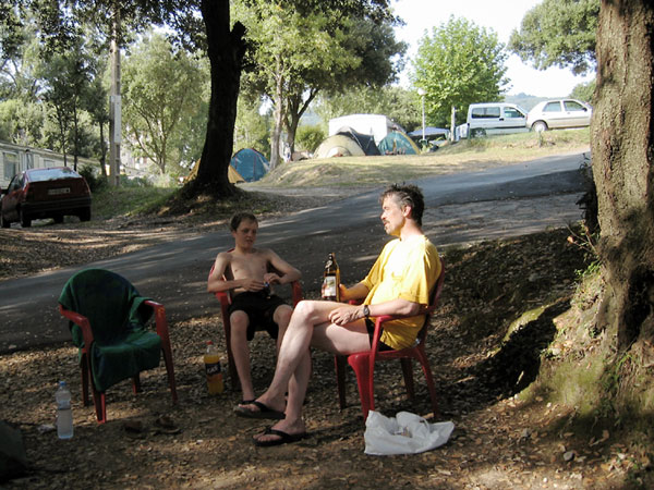 Ernst en Pieter op plastic stoeltjes in de schaduw, flesje bier erbij