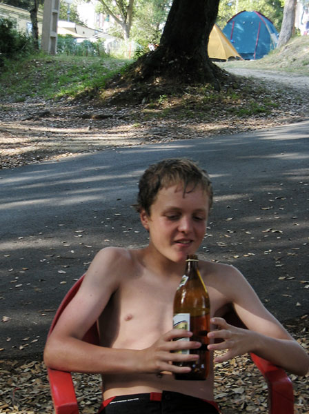 Pieter in de schaduw, met een fles bier in z'n hand
