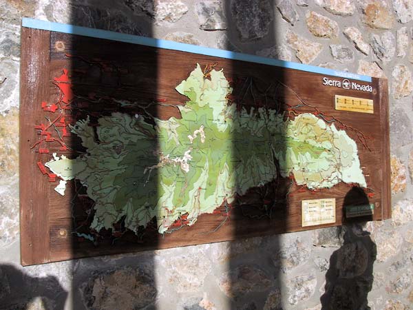 Houten bord met kaart van de Sierra Nevada, op ruwstenen muur