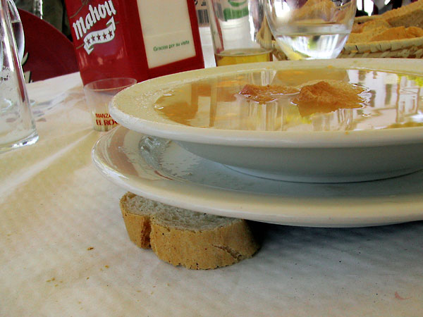 Bord met soep, aan 1 kant ondersteund door stuk brood