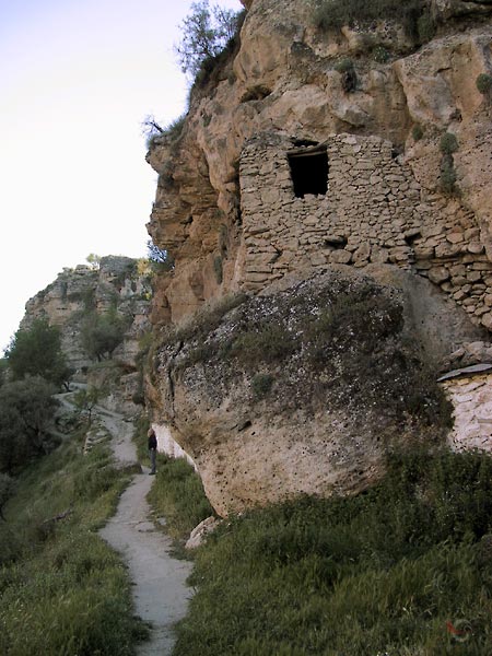 Gemetselde muur met opening in rotswand