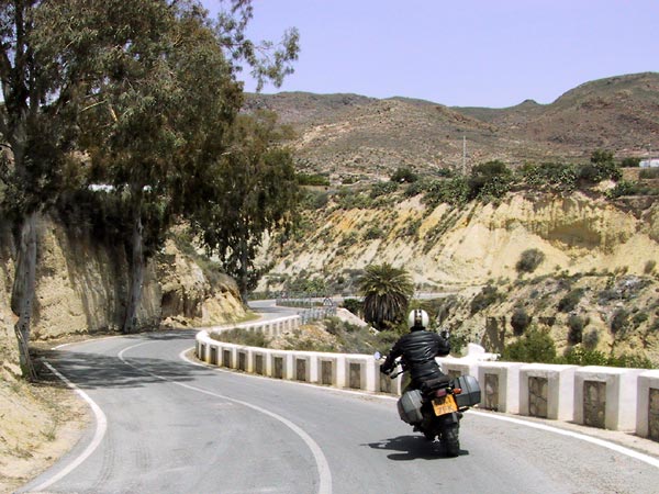 Bochtige asfaltweg langs gele rotsen