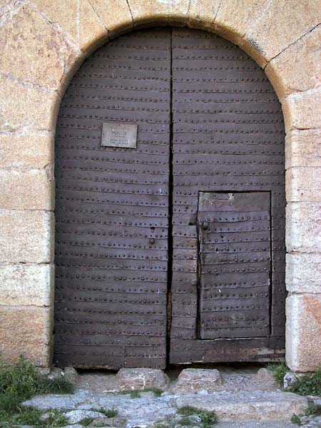 Ronde poort met houten deuren vol ijzeren beslag