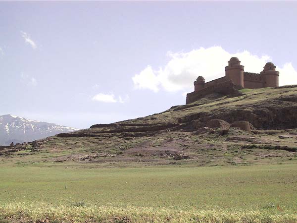 Het kasteel van verderaf met de besneeuwde Sierra Nevada op de achtergrond