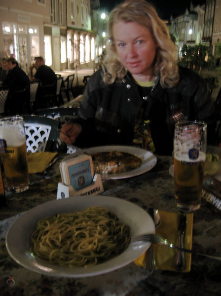 Eg moe kijkende Sylvia, buiten, met bier en Italiaans eten