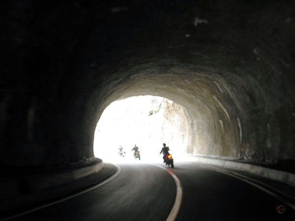 Donkere tunnel, drie motoren die de uitgang uit rijden