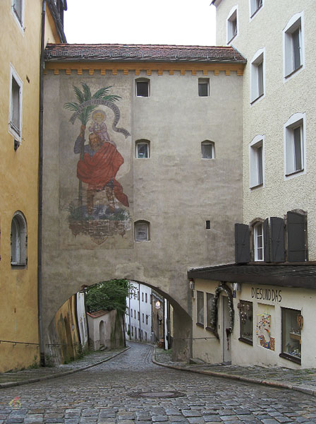 Steeg met kinderkopjes, onder gebouw door met schildering van Sint Christofoor