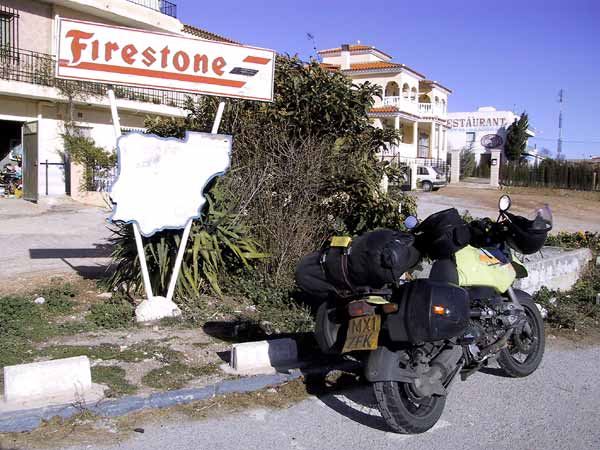 Bepakte motor voor reclamebord van Firestone met vervaagde kaart van Spanje