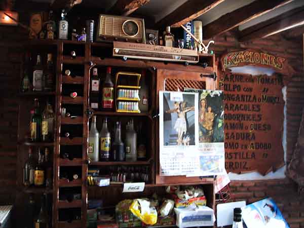 Achter de bar: houten kastjes en veel flessen