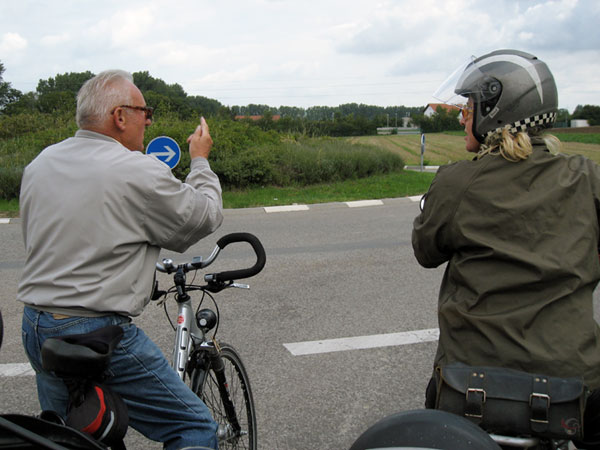 man wijst motorrijder de weg