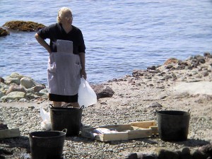 Vrouw met vis bij de zee