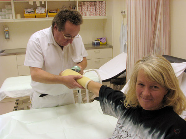 Nurse removes plaster from hand with a kind of saw