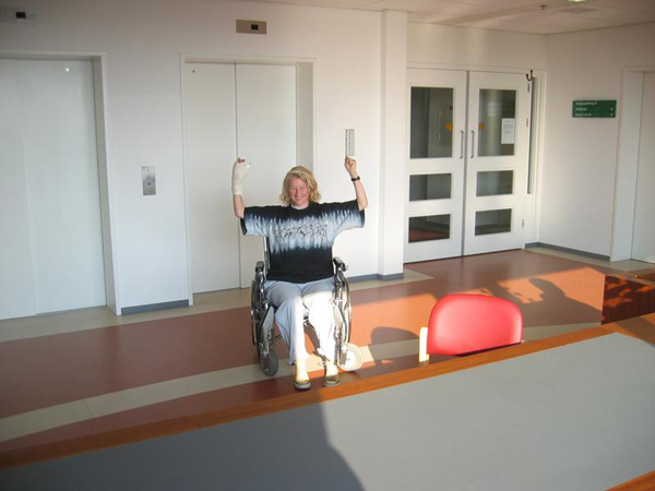 Sylvia, arms up, in a wheel chair