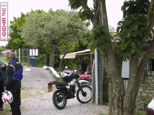 Bordje van restaurant, geparkeerde XT250, en een motorrijder