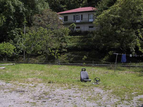 Huis, groot grasveld, autostoel en stuur