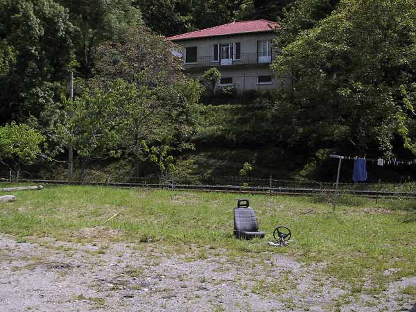 Huis, groot grasveld, autostoel en stuur