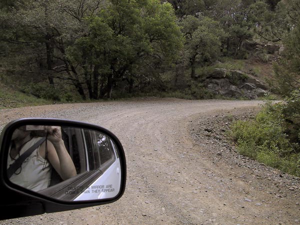 Fotograaf in autospiegel, onverharde weg