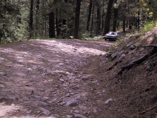 Een volkomen ongeschikte auto op een rotsige hobbelweg