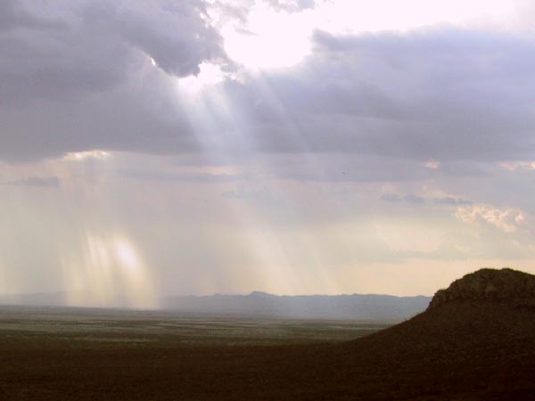 Zonnestralen vallen uit de wolken op de vlakte