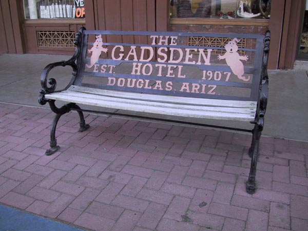 Bench with ghost, and text: Gadsden Hotel