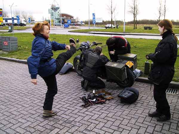 Hans en Steffen sleutelen aan de Magna; Sylvia maakt lachend schopbeweging