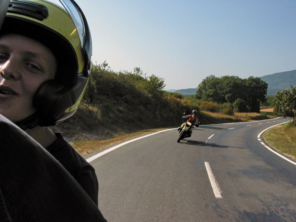 Pieter's hoofd met helm, Sylvia daar achter op de motor