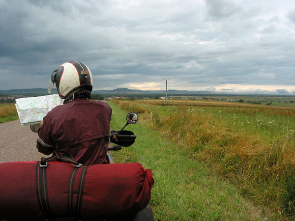 Sylvia stilstaand met motor met kaart, donkere wolken in de verte