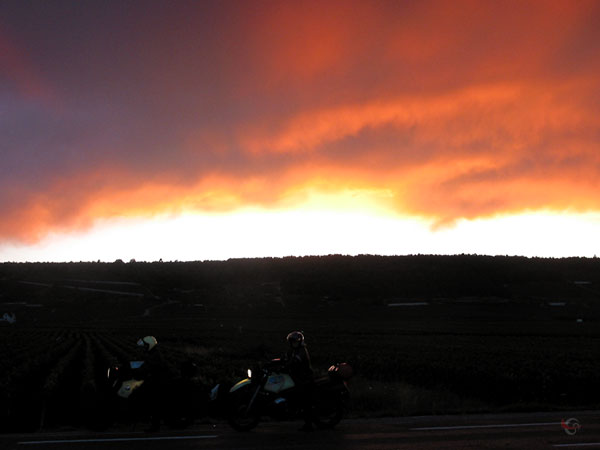 Twee motoren in het donker met daarboven een oranje lucht