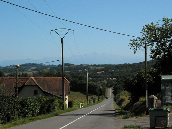 Rechte weg in heuvellandschap, in verte heel vaag de Pyreneeën