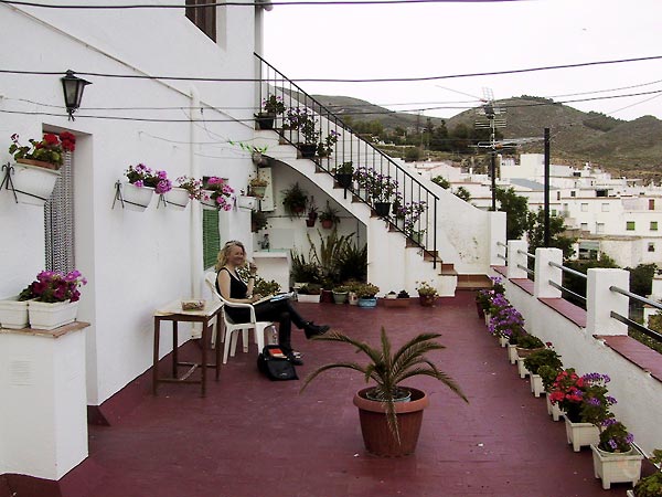 Sylvia op dakterras vol geraniums en petunia's