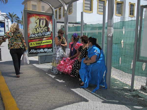 Vrouwen in flamencojurken in een bushokje