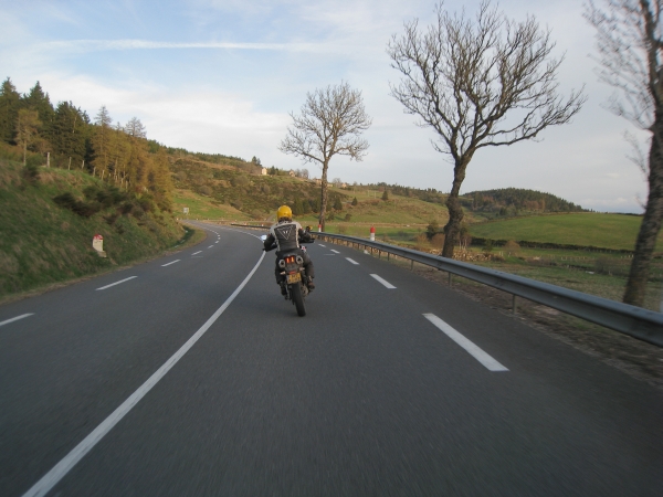 Landschap met stenen muurtjes, motorrijder en bocht