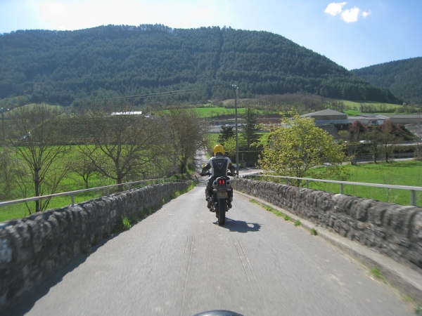 Motorrijder over stenen bruggetje