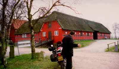 Ernst and motorcycle in front of a red farm
