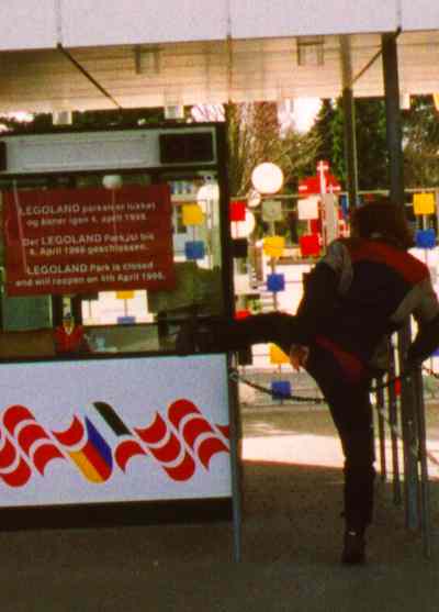 Sylvia trying to climb over a chain at a ticket booth