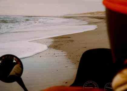 The sea and the beach, seen from the back of the motorcycle