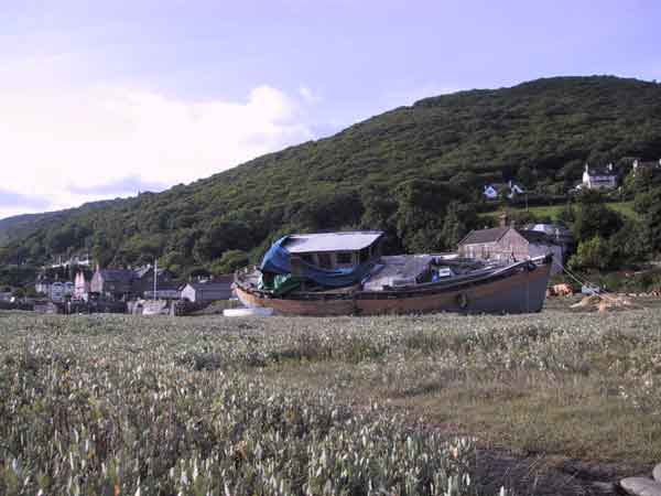 Boten op het droge, hoge beboste heuvels daarachter