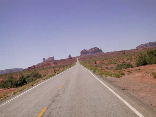 Asfaltweg met Monument Valley aan de horizon