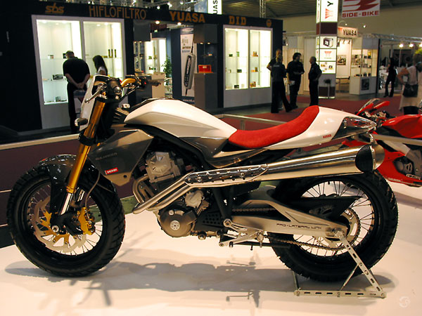 Slender motorcycle with high exhaust, in red and aluminium
