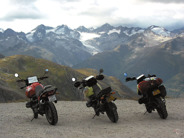Driemaal een BMW R1100GS, besneeuwde bergtoppen