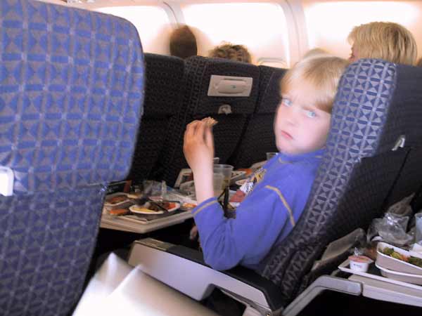 Pieter aan het smullen in het vliegtuig