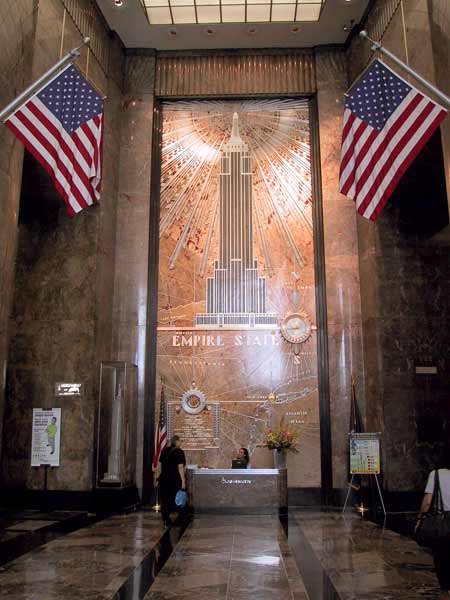 Marmeren gang; de wand ook van marmer, met afbeelding van het Empire State Building
