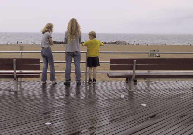 Karin, Wouter en Pieter kleumend op de natte boardwalk bij het strand