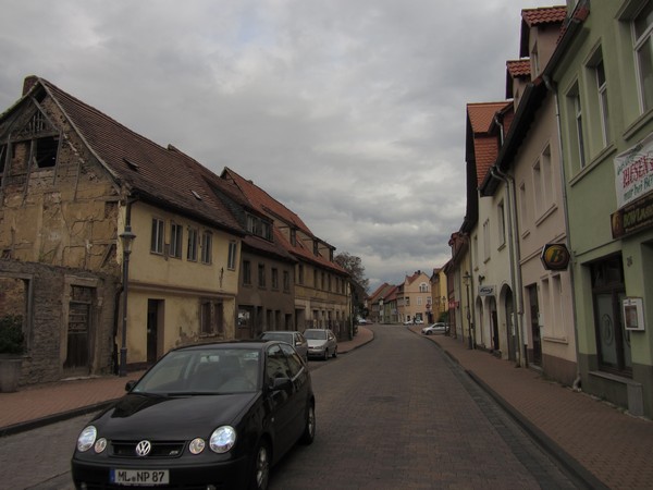 Tenere in straat met bouwvallig huis