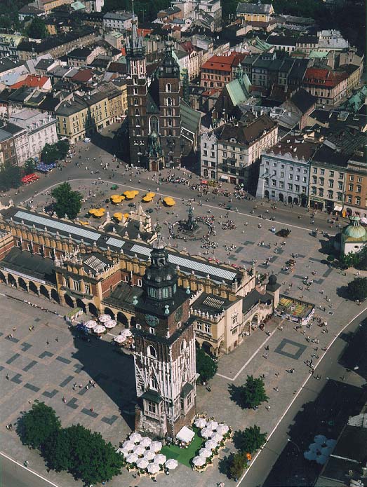 Photograph from the air: a square with covered market, tower and old houses