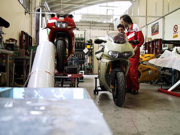 Motorcycle factory, two man talking and two motorbikes
