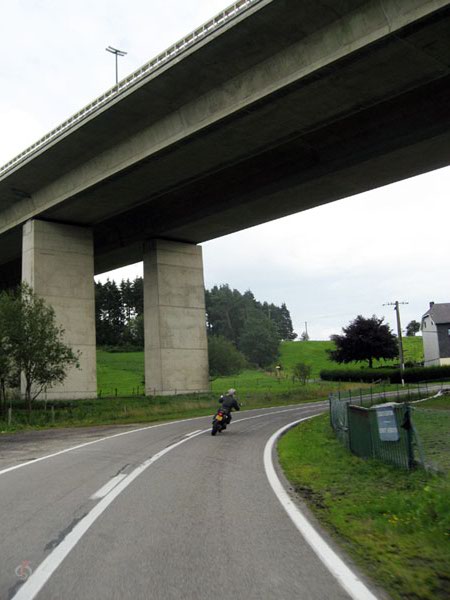 Tricker rijdt onder enorm viaduct door